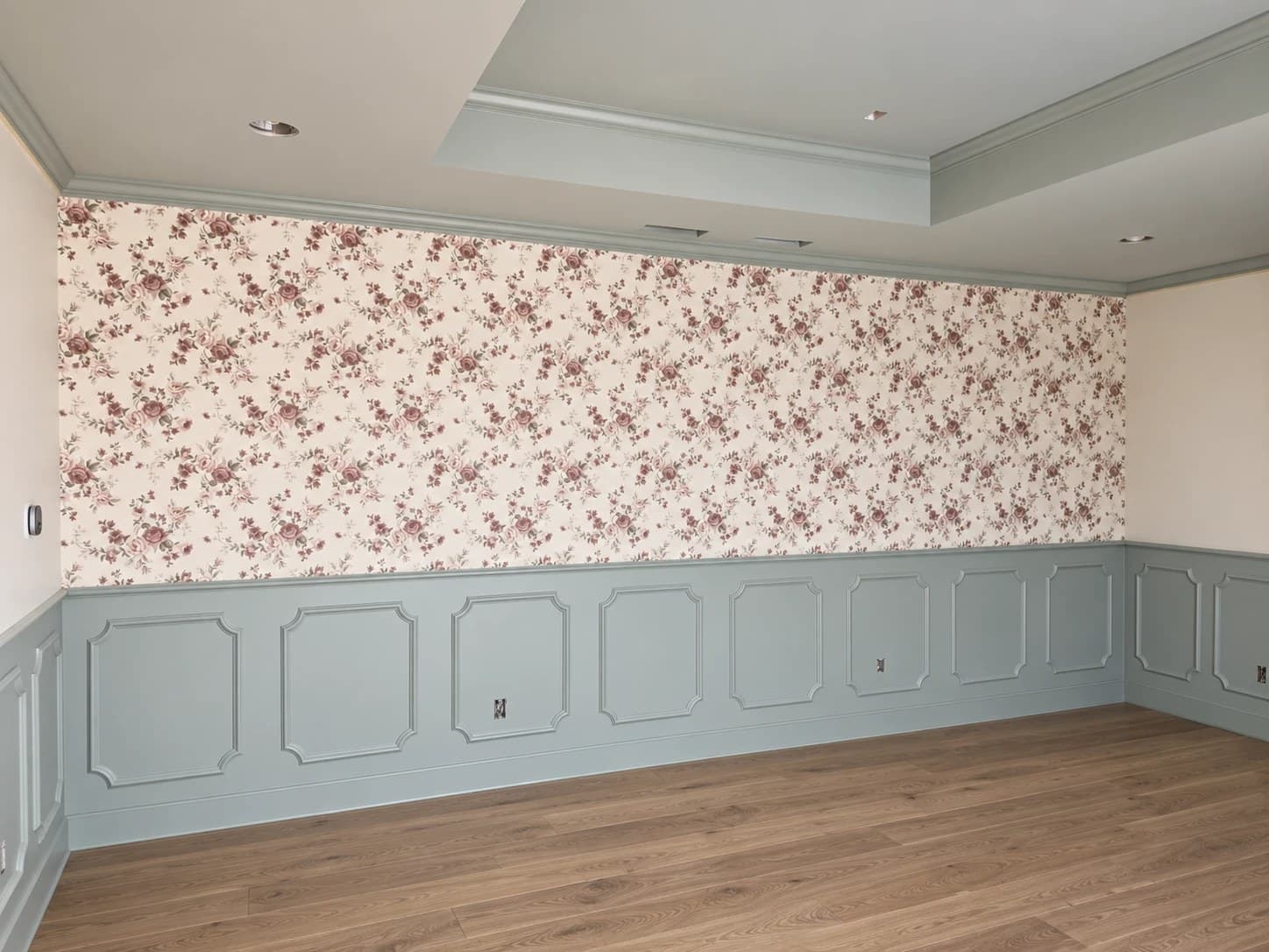 Full wall of rose wallpaper above painted wainscoting