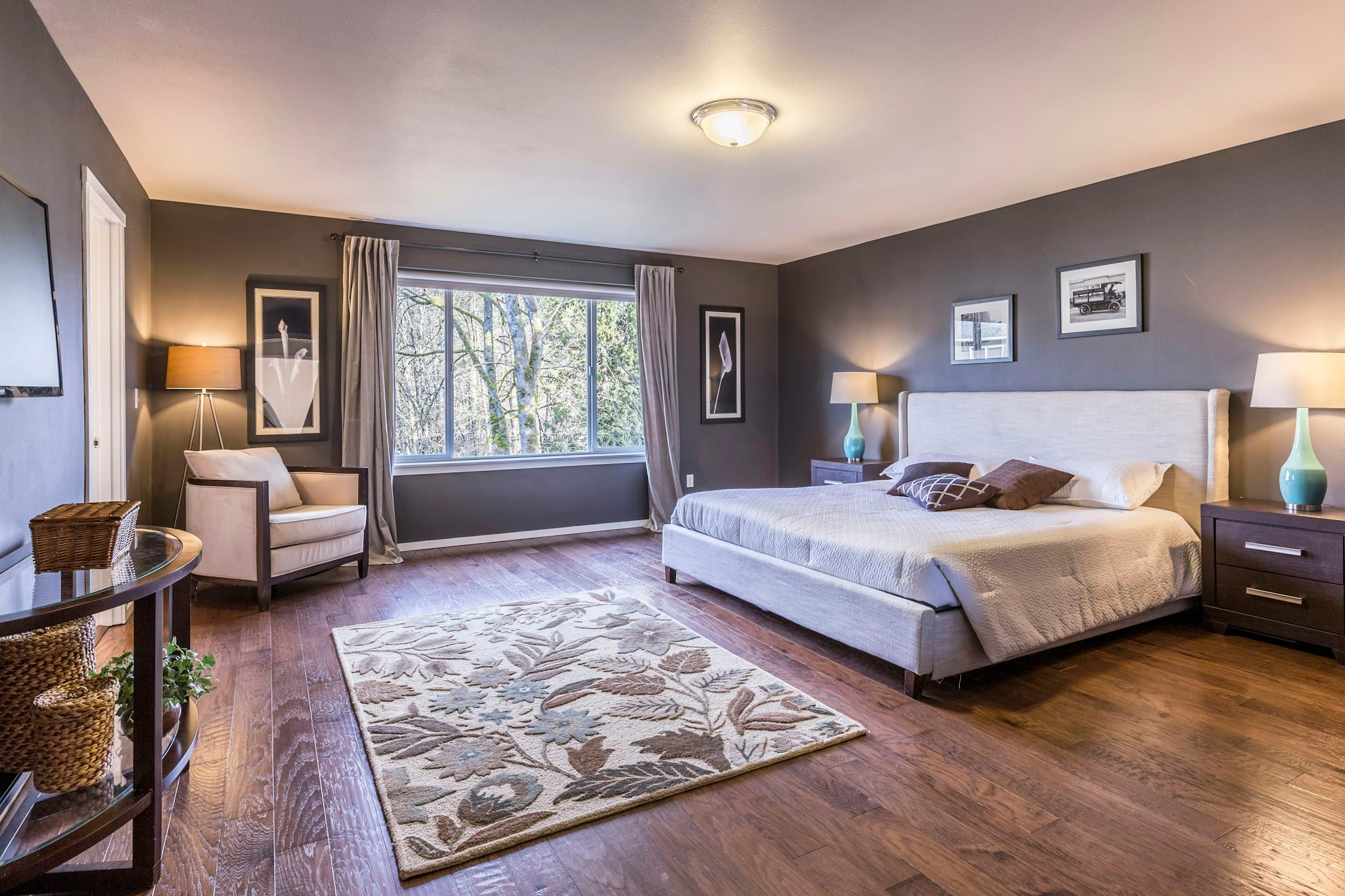 A sophisticated bedroom with framed artwork professionally hung above the bed