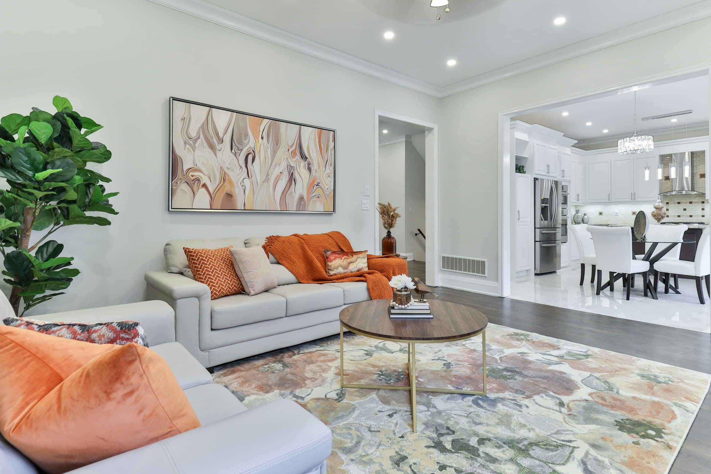 A living room with large framed artwork professionally hung above the sofa